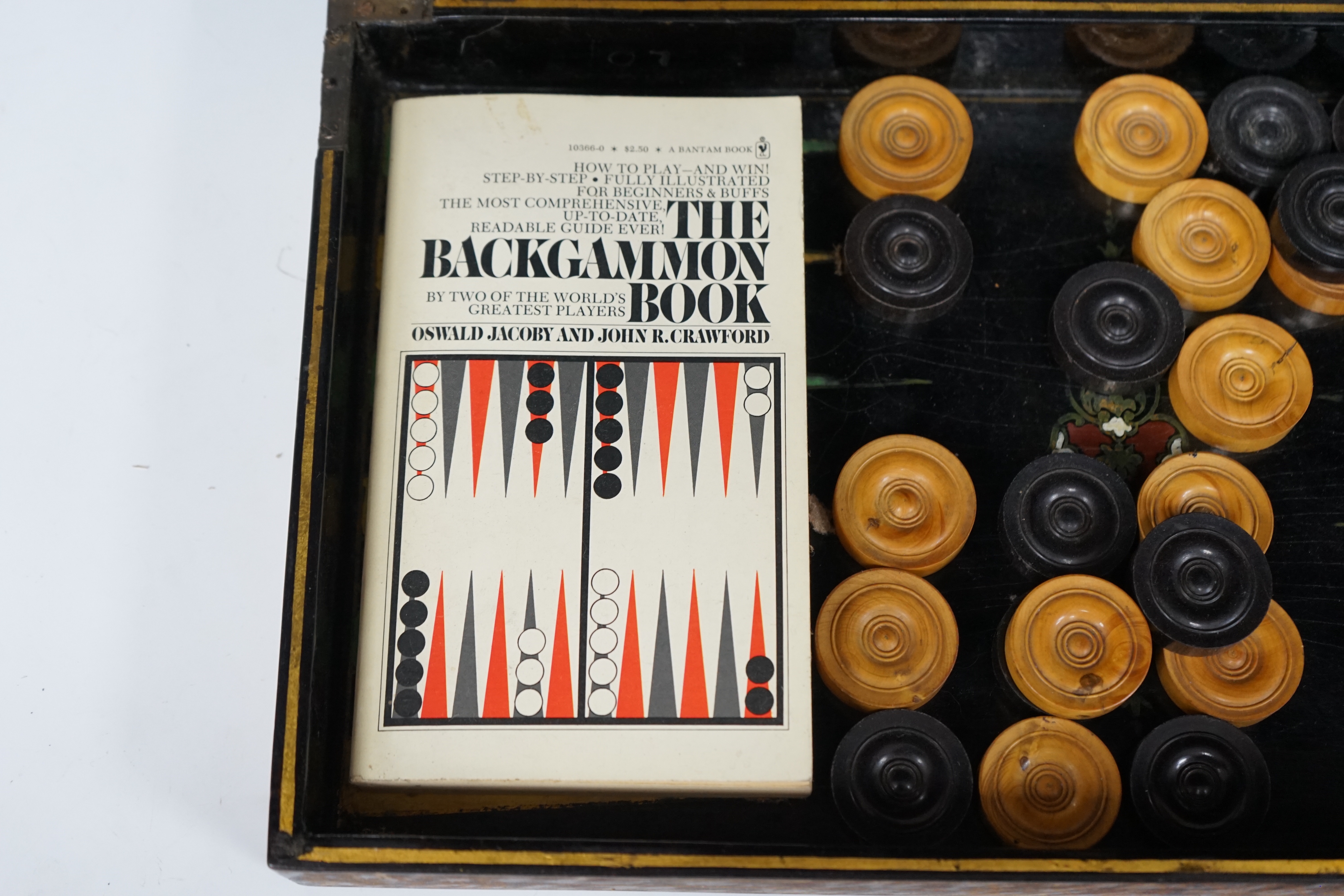 A 19th century papier maché folding games board for chess and backgammon, containing a wooden draughts set etc. with gilt decoration, 41 x 45cm unfolded
